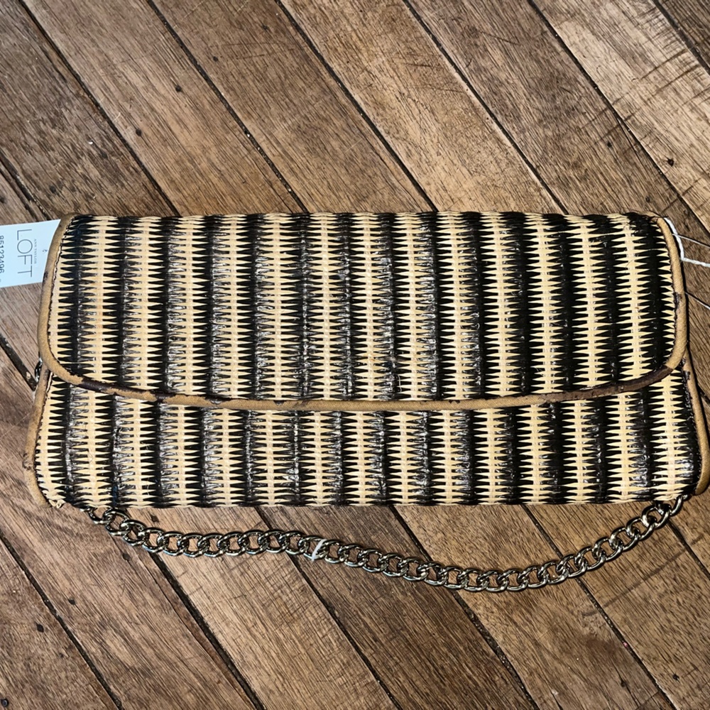 LOFT brown and beige woven clutch with a chain strap.